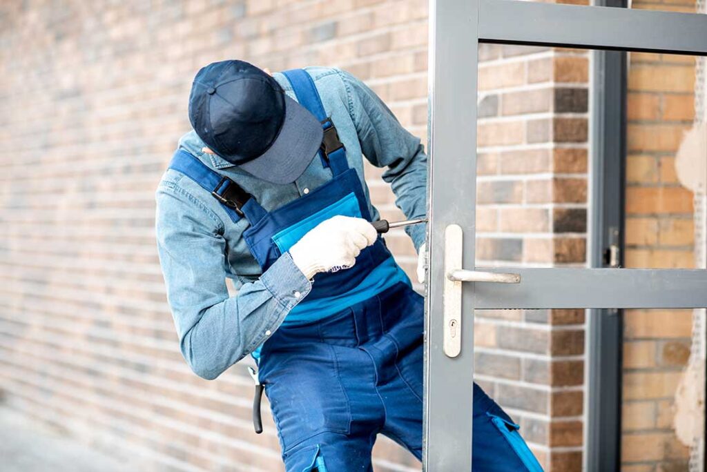 workman-in-blue-installing-lock-on-outside-door